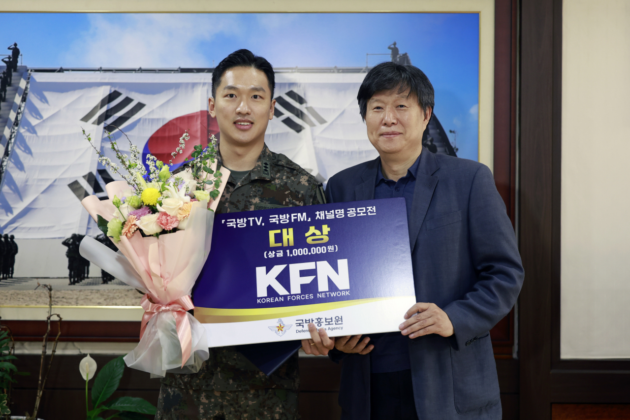 국방홍보원장(채일, 오른쪽)이 11일 오후 「국방TV, 국방FM」 채널명 공모전 대상 수상자 육군 1사단 최승호 대위(왼쪽)에게 시상하고 있다.[국방홍보원 제공]