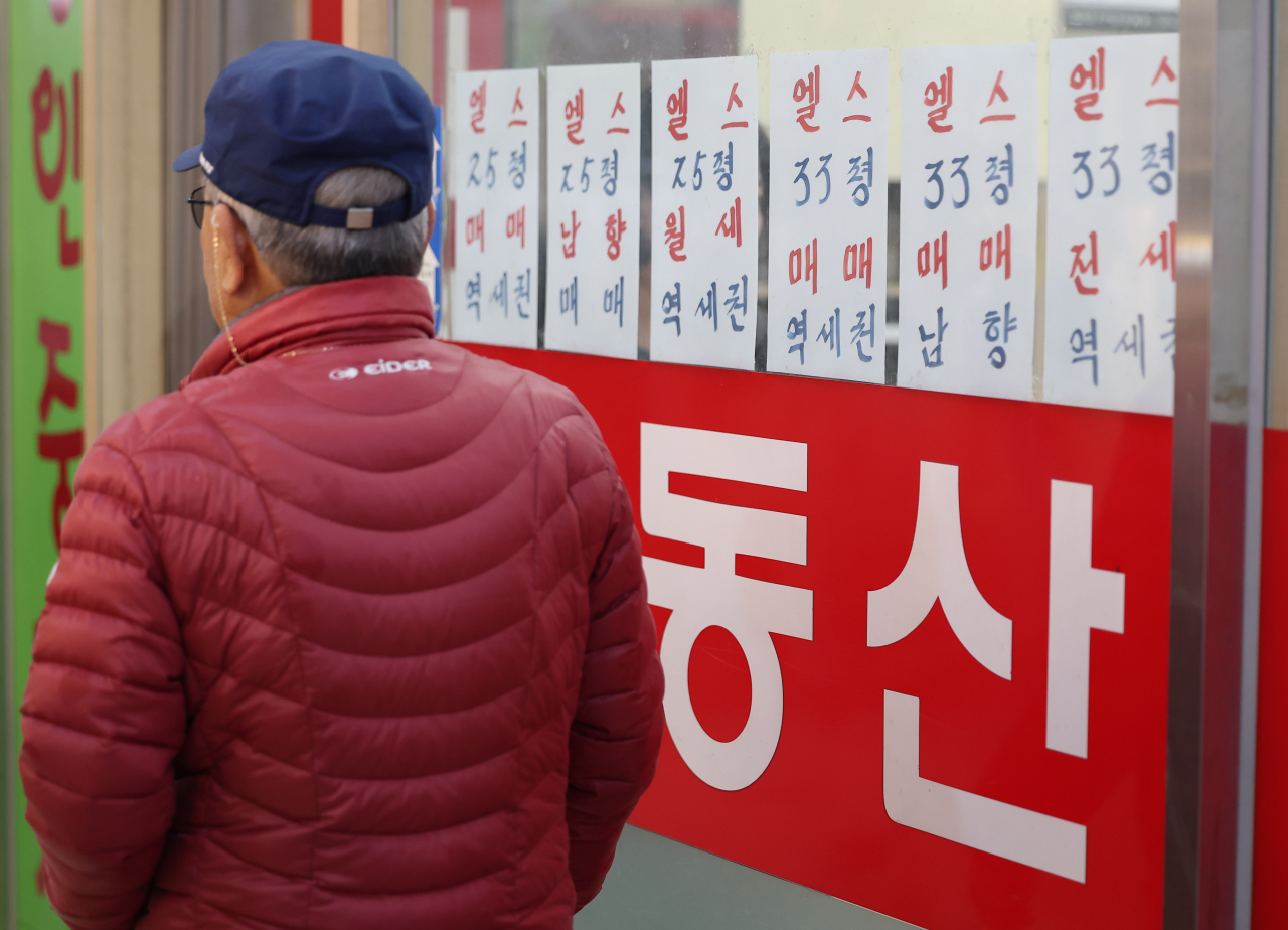 서울 한 부동산중개사무소 앞을 시민이 지나가고 있다.[연합]