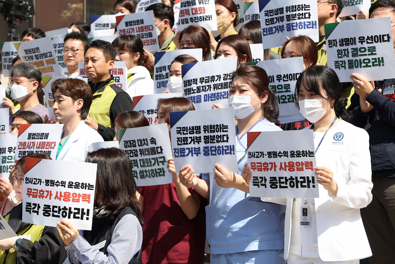 서울지역 전공의 수련병원 노동조합 대표자들이 1일 오전 서울 서대문구 세브란스병원 앞에서 '대형 의료기관 노조 대표자회의, 진료거부사태 장기화에 따른 입장 발표 기자회견'을 열자 의료진이 손팻말을 들고 있다. [연합]