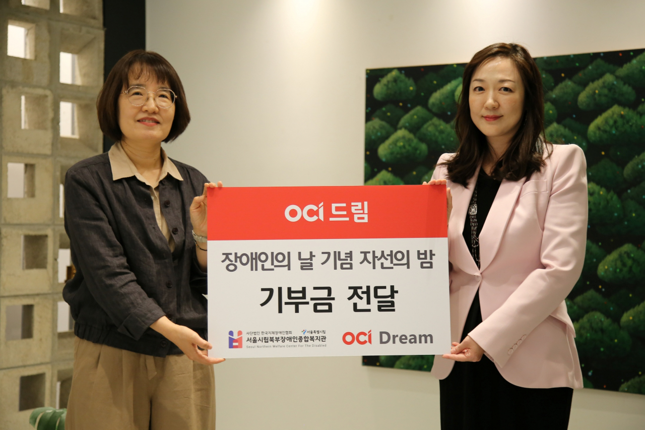 18일 OCI 본사에서 열린 다 함께 드림 자선행사에서 이지현(오른쪽) OCI드림 대표가 신연화 서울시립북부장애인종합복지관 관장에게 기부금을 전달한 후 기념사진을 촬영하고 있다. [OCI 제공]