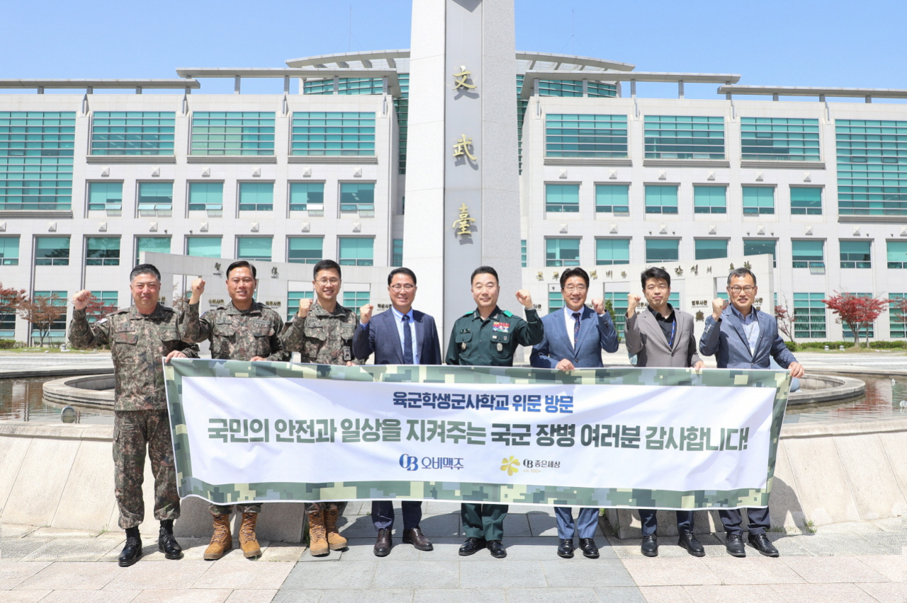 최상범(왼쪽 네번째부터) 오비맥주 영업부문 부사장, 육군학생군사학교 김동호 소장, 김부영 충청권역 본부장이 위문품을 전달하고, 기념 사진을 촬영하고 있다. [오비맥주 제공]