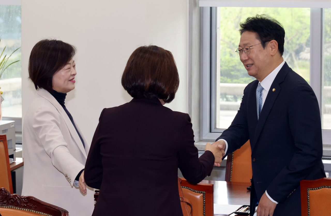 진선미(왼쪽) 더불어민주당 원내대표·의장단 선출 선관위원장이 24일 국회에서 1차 회의 전 황희(오른쪽) 의원 등과 인사하고 있다. [연합]
