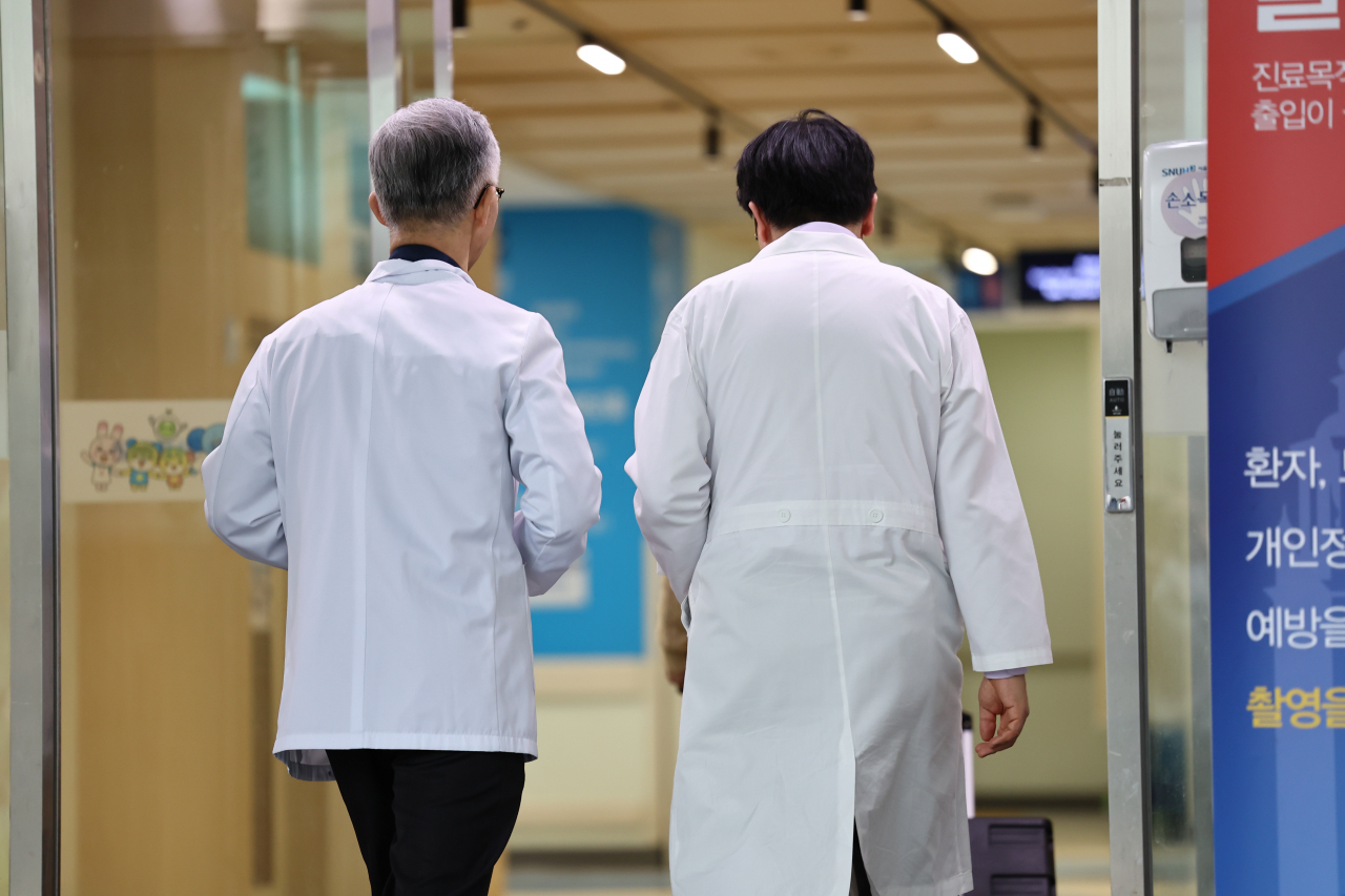 총회가 열리는 23일 오후 서울의대 교수들이 회의실이 위치한 서울대학교병원 어린이병원 건물로 들어서고 있다. 이날 열린 총회에서 서울의대 교수비대위는 일주일에 하루 요일을 정해 외래 진료와 수술을 하지 않는 방식의 휴진을 의결 안건으로 올릴 예정이다. [연합]