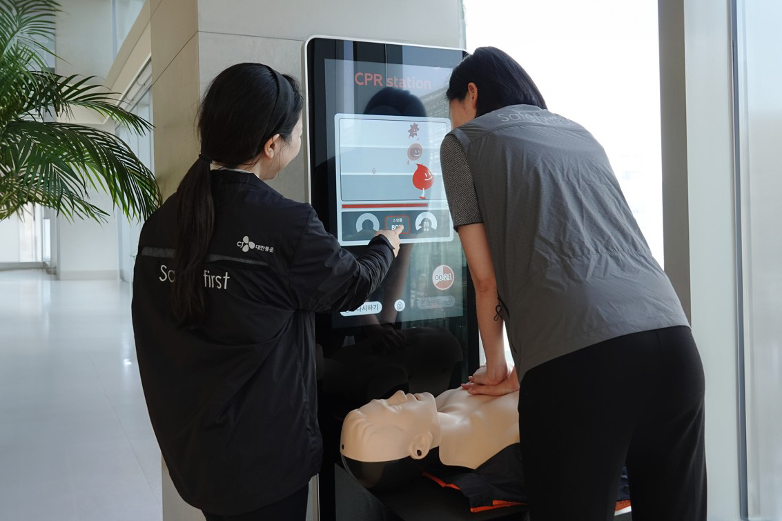 CJ대한통운 서울 본사에서 한 직원이 심폐소생술 키오스크 모니터를 보면서 셀프 교육을 받고 있다. [CJ대한통운 제공]