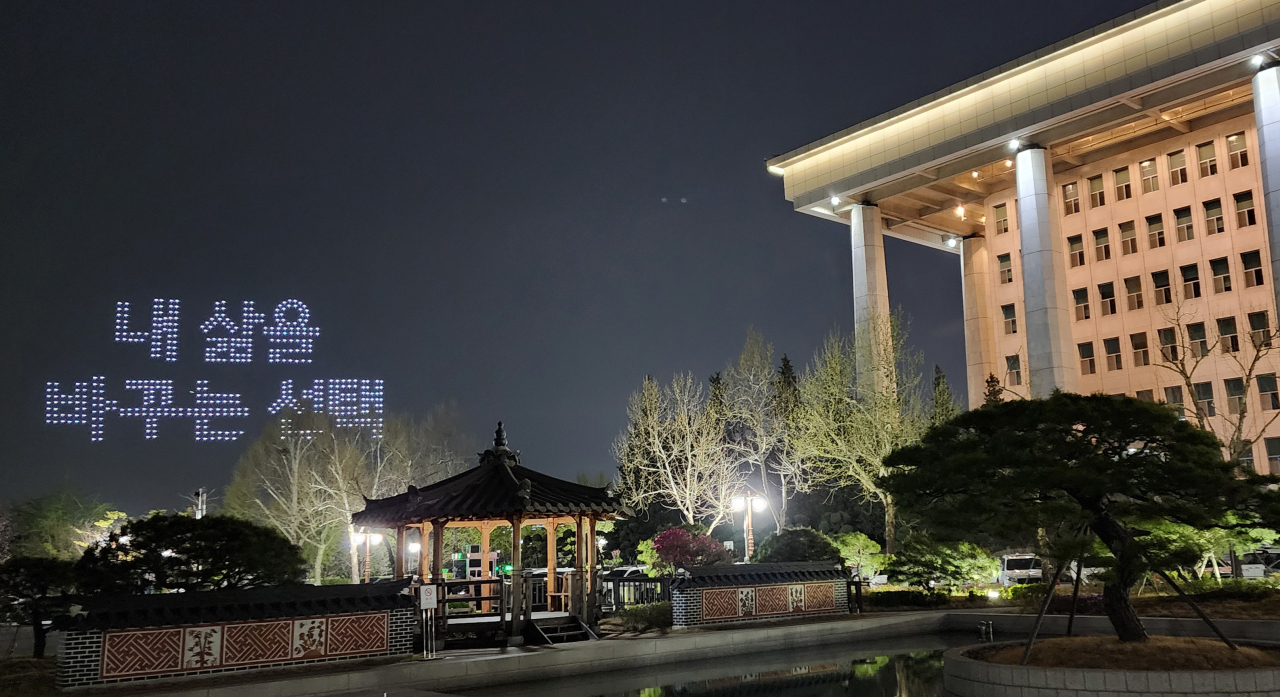 4.10 총선 투표일인 10일 밤 국회 뒤로 한 방송국이 진행한 드론쇼가 보인다. [연합]