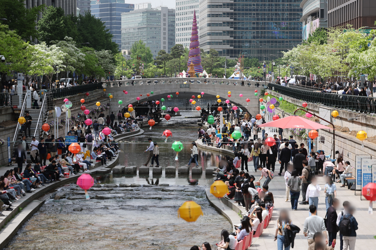 지난 26일 점심시간에 서울 청계천을 찾은 직장인들이 산책을 즐기고 있다. 연합뉴스