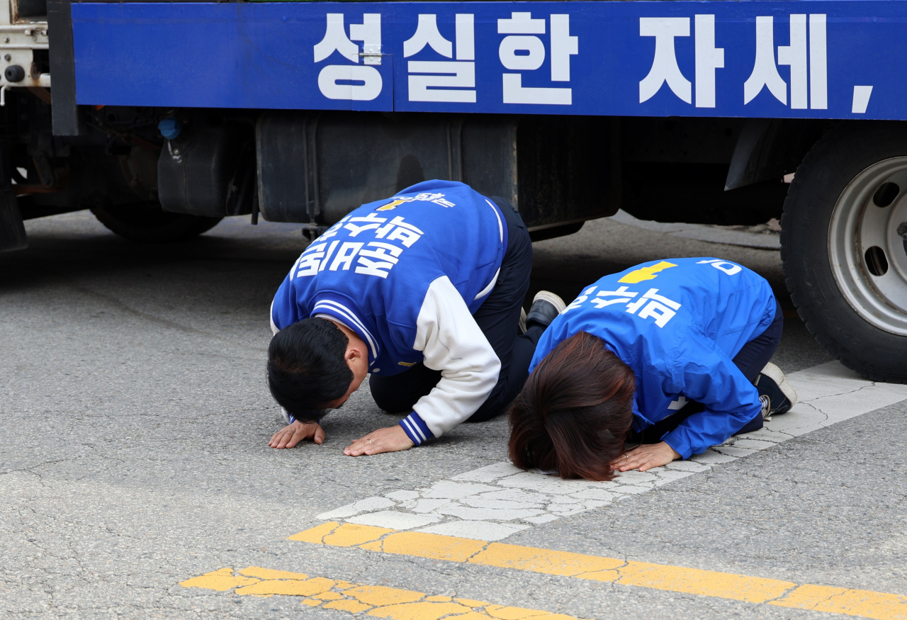 4·10 총선 사전투표 마지막 날이었던 지난달 6일 더불어민주당 박수현 충남 공주·부여·청양 선거구 후보가 공주 산성시장에서 거리유세를 한 뒤 아내와 함께 큰절을 하고 있다. [연합]