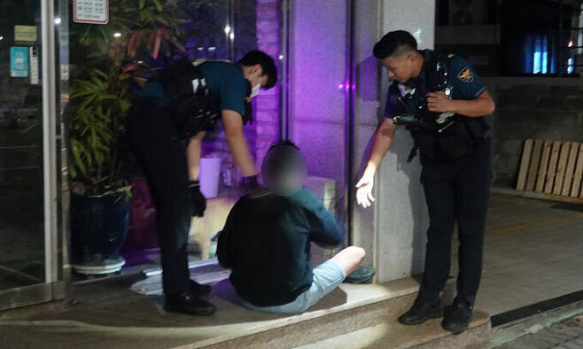 노상 주취자를 귀가 조치 시키고 있는 경찰 모습[뉴시스]