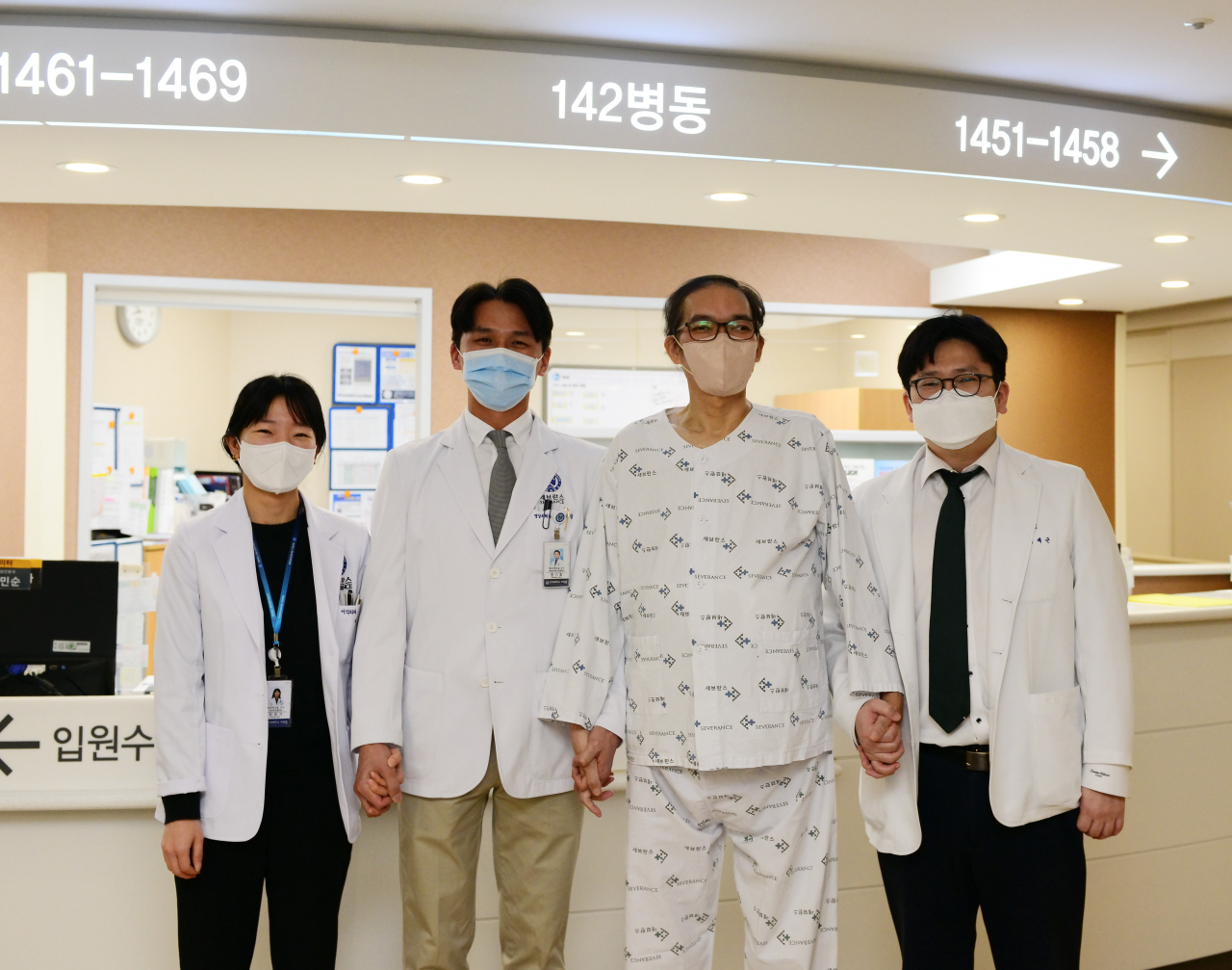 (왼쪽부터) 민은기, 한기창, 이재근 교수가 정민수 씨(오른쪽에서 두 번째)와 사진 촬영을 하고 있다.[세브란스병원 제공]