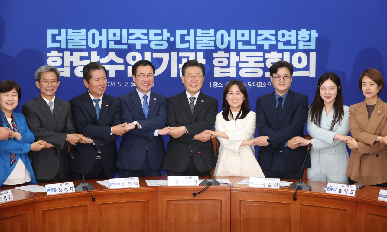 이재명(왼쪽 다섯번째) 더불어민주당 대표와 더불어민주연합 윤영덕(왼쪽 네번째), 백승아(왼쪽 여섯번째) 공동대표 등이 2일 국회에서 열린 '더불어민주당-더불어민주연합 합당수임기관 합동회의'에서 손을 맞잡고 기념촬영을 하고 있다. [연합]