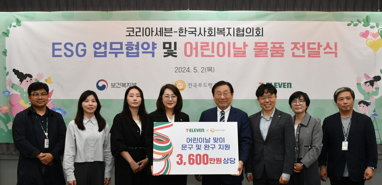 조수경 코리아세븐 상품본부장(왼쪽에서 네번째)과 김성이 한국사회복지협의회 회장(왼쪽에서 다섯 번째)이 업무협약 체결식에서 참석자들과 기념 촬영을 하고 있다.[한국사회복지협의회 제공]