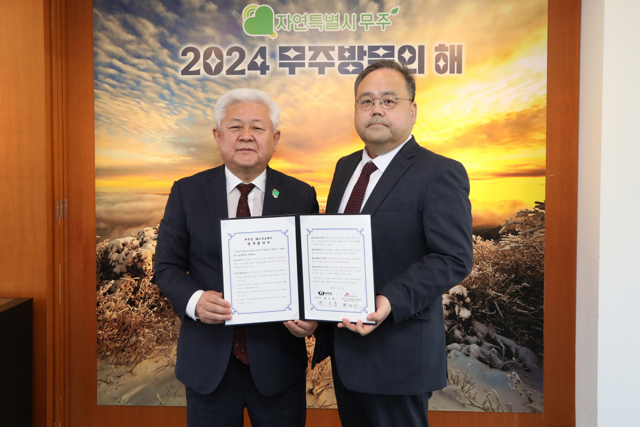 박인서 SK브로드밴드 케이블방송사업단 제작본부장(오른쪽)과 황인홍 무주군수가 업무협약식에서 기념촬영을 하고 있다. [SK브로드밴드 제공]
