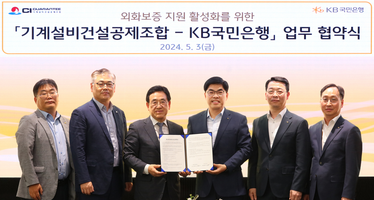 지난 3일 서울시 영등포구 여의도 소재 KB국민은행 신관에서 열린 '외화보증 지원 활성화를 위한 기계설비건설공제조합-KB국민은행 업무 협약식'에서 김종서(왼쪽에서 세번째) 기계설비건설공제조합 이사장 직무대행과 이상신(오른쪽에서 세번째) KB국민은행 외환사업본부장 및 양사 관계자들이 기념사진을 촬영하고 있다.[KB국민은행 제공]