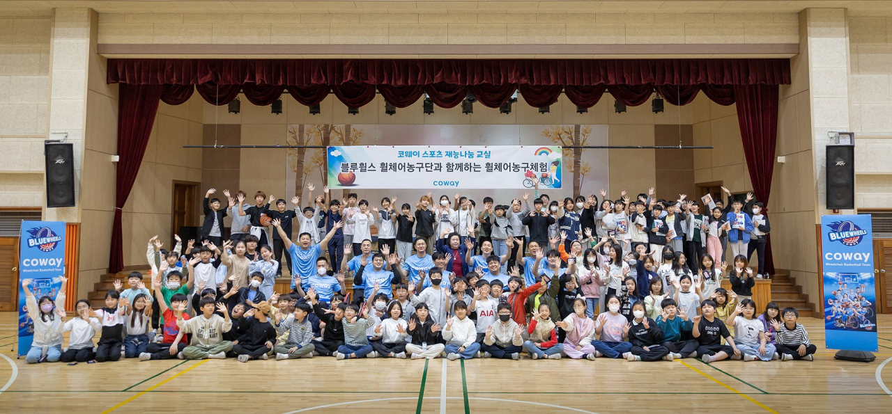 남양주 평내초등학교를 방문한 코웨이 블루휠스 휠체어농구단이 학생들과 기념 촬영을 하고 있다. [코웨이 제공]