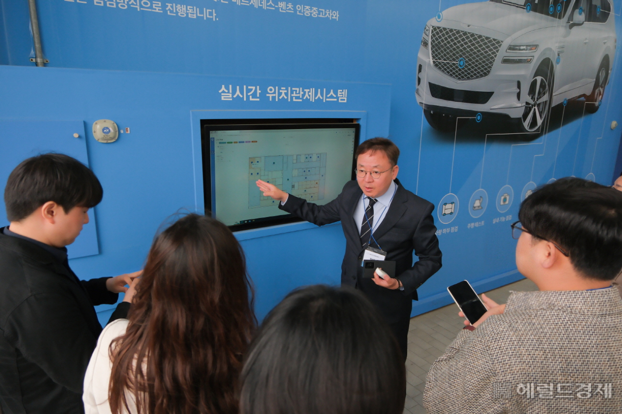 지난 7일 세계 최초 ‘EV·PHEV 정비 부문’ 2년 연속 티유브이슈드 인증을 기념해, 오토플러스의 직영 리컨디셔닝센터 ‘ATC’에서 박종호 생산본부장이 ATC 내 실시간 위치관제시스템을 소개하고 있다. [사진=오토플러스]