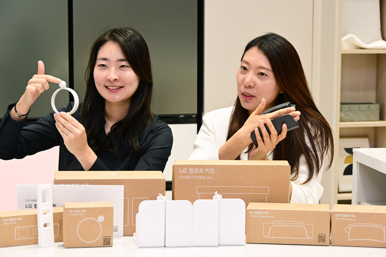 ‘LG 컴포트 키트’ 개발 및 출시를 함께 한 공희원(왼쪽) LG전자 H&A상품기획담당 책임과 김혜원(오른쪽) LG전자 H&A디자인연구소 선임연구원이 세탁기와 건조기 등에 부착해 사용할 수 있는 이지볼과 이지핸들에 대해 설명하고 있다. 세탁기나 건조기 다이얼에 끼우는 이지볼은 근력이 약하거나 몸이 불편한 고객이 쉽게 다이얼을 돌릴 수 있도록 도와준다. 이지핸들은 세탁기, 건조기, 냉장고 도어를 쉽게 여닫을 수 있도록 설계됐다. [LG전자 제공]