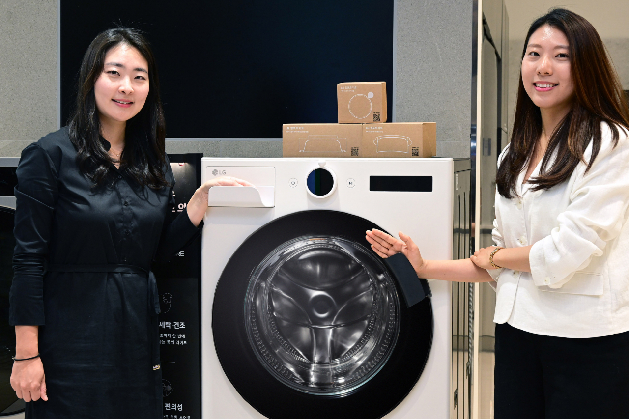 ‘LG 컴포트 키트’ 개발 및 출시를 함께 한 공희원(왼쪽) LG전자 H&A상품기획담당 책임과 김혜원(오른쪽) LG전자 H&A디자인연구소 선임연구원이 LG전자 세탁기에 부착된 ‘이지핸들’을 소개하고 있다. [LG전자 제공]