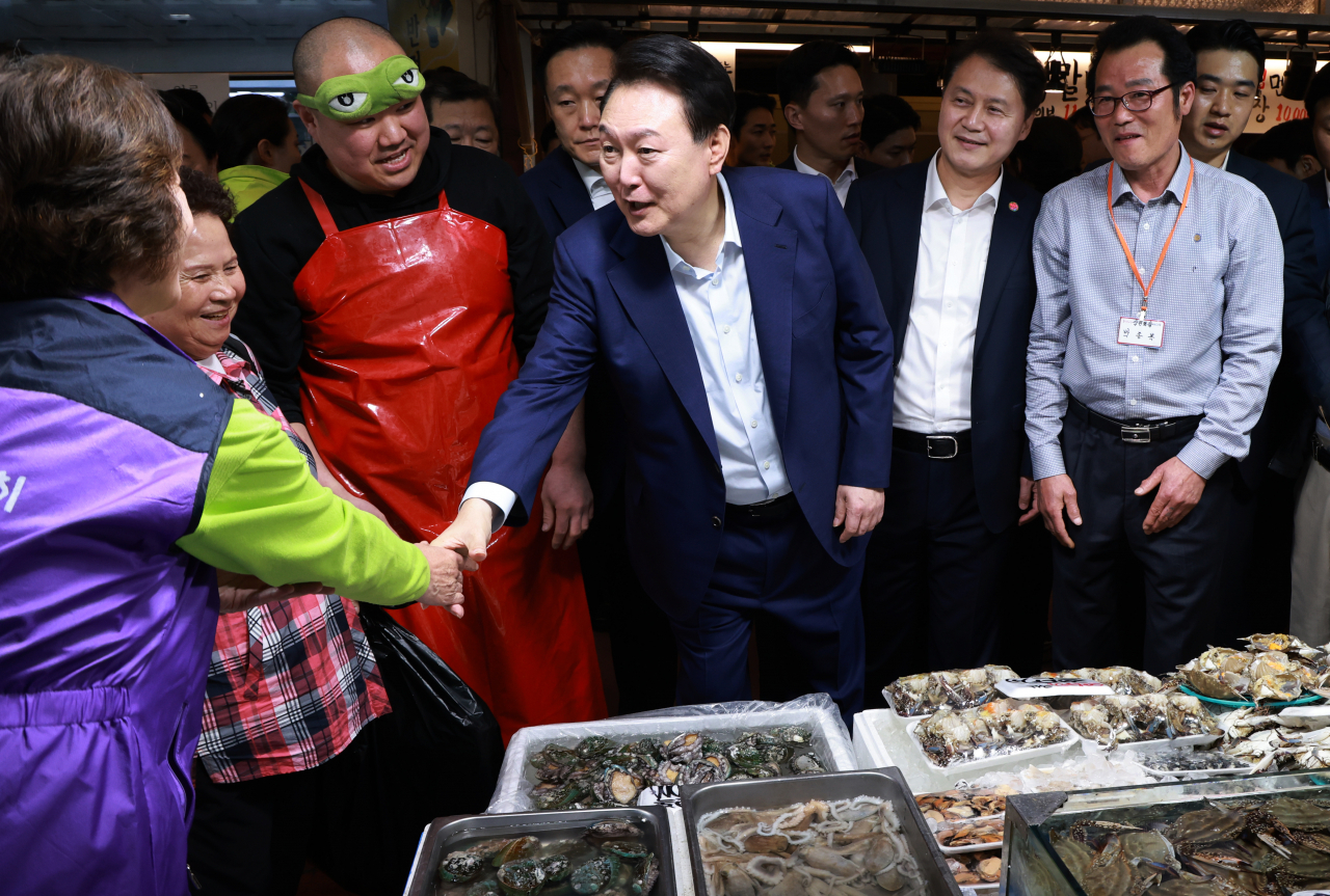 윤석열 대통령이 10일 오후 서울 서대문구 영천시장을 찾아 수산 매장에서 상인과 인사하고 있다. [연합]