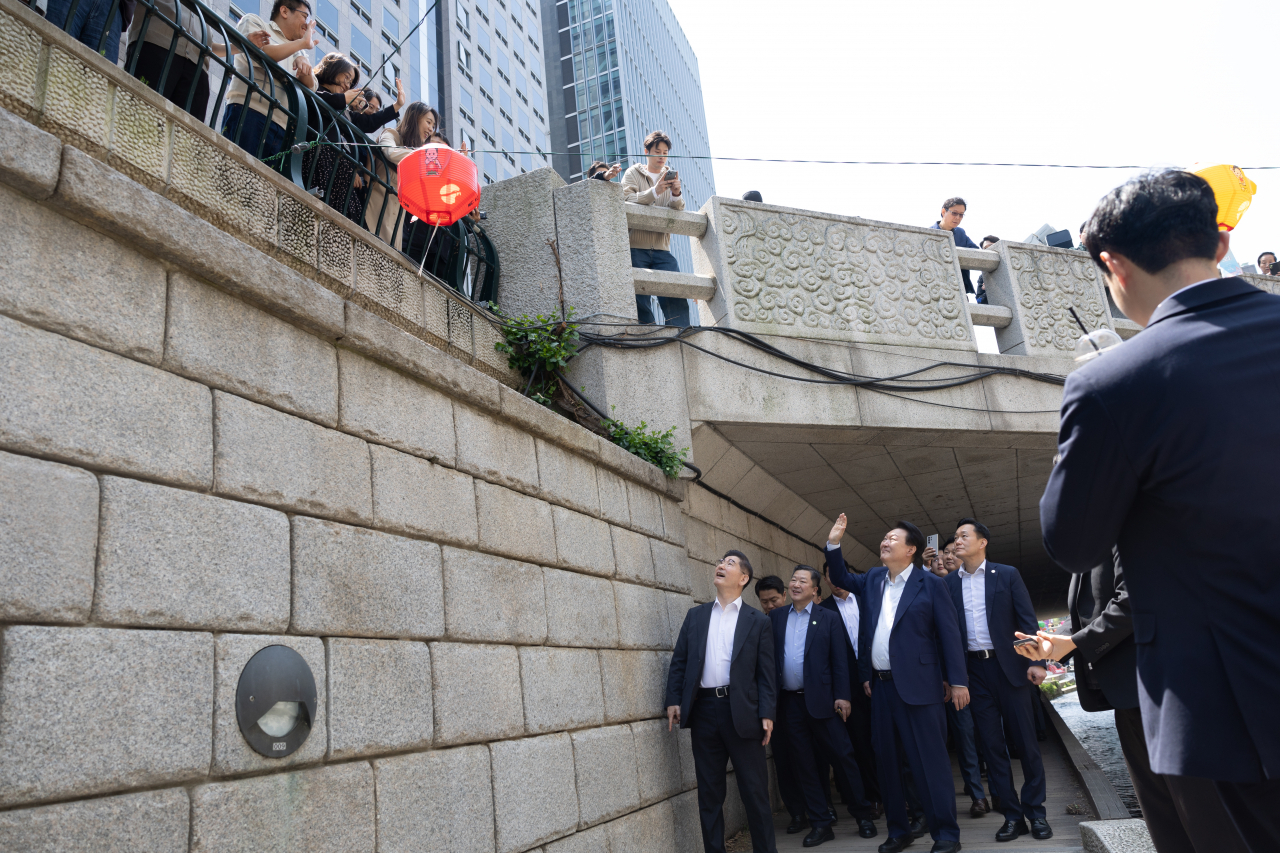 윤석열 대통령이 10일 서울 중구 청계천을 찾아 인근 직장인, 시민들과 인사하고 있다. [연합]