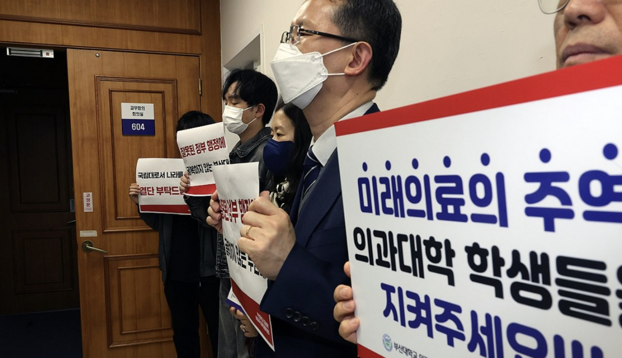 부산대 의대 증원 관련 학칙 개정을 위해 교무회의가 열리는 지난 7일 이 대학 대학본부에서 의과대학생들과 교수들이 피켓 시위를 하고 있다. [연합]