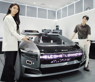 LG이노텍 직원들이 미래차 목업(Mock-up)에 장착된 차량 조명 모듈 ‘넥슬라이드’를 선보이고 있다. [LG이노텍 제공]