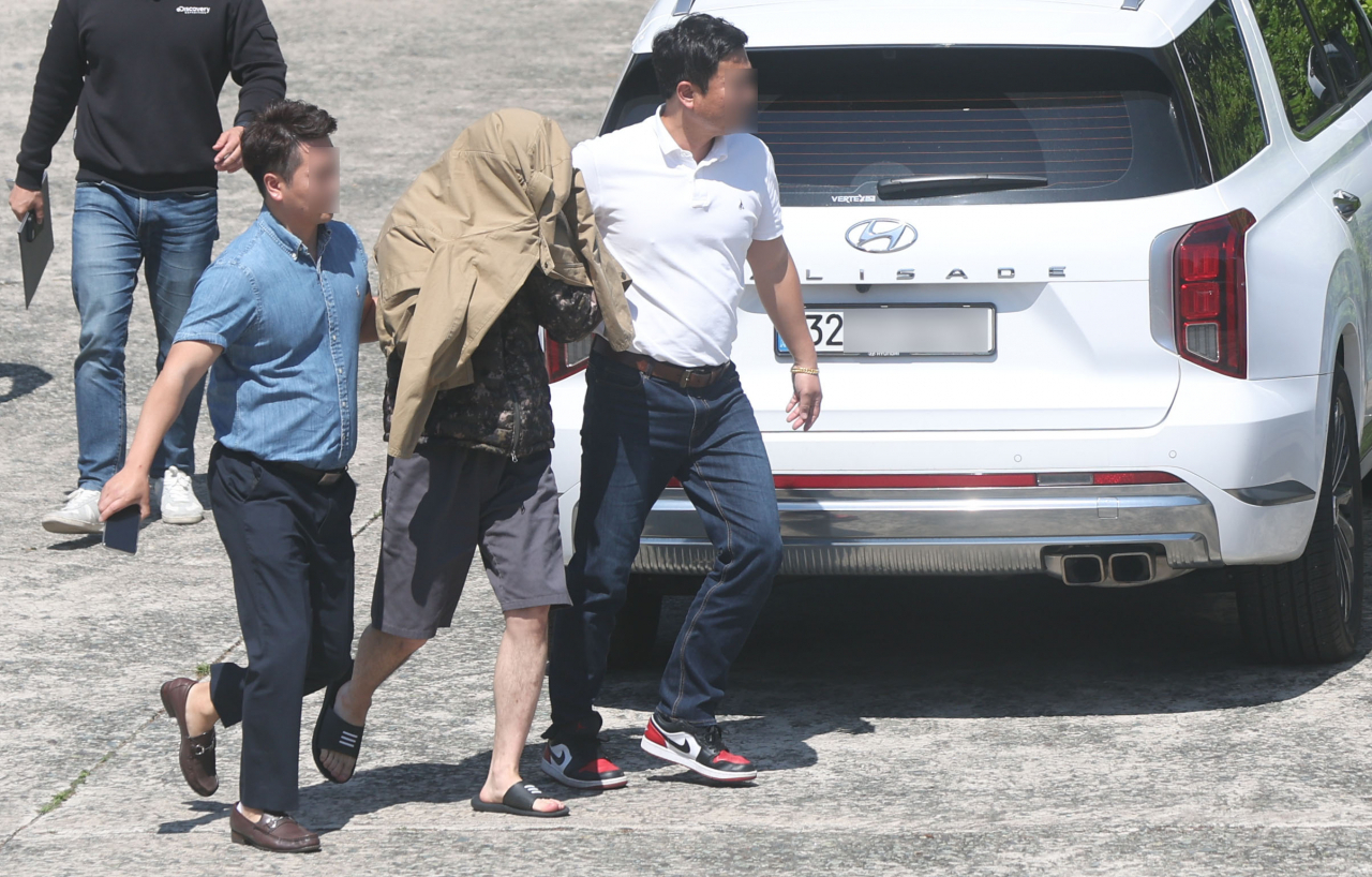 태국 파타야에서 한국인을 살해한 혐의를 받은 A씨가 2차 조사를 위해 13일 오후 경남 창원시 성산구 경남경찰청 형사기동대로 이동하고 있다. [연합]