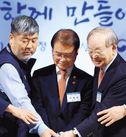 올해 초 열린 ‘2024 노사정 신년인사회’에서 손경식(오른쪽) 한국경영자총협회 회장이 김동명(왼쪽) 한국노총 위원장, 이정식(가운데) 고용노동부 장관과 함께 떡을 자르고 있는 모습 [연합]
