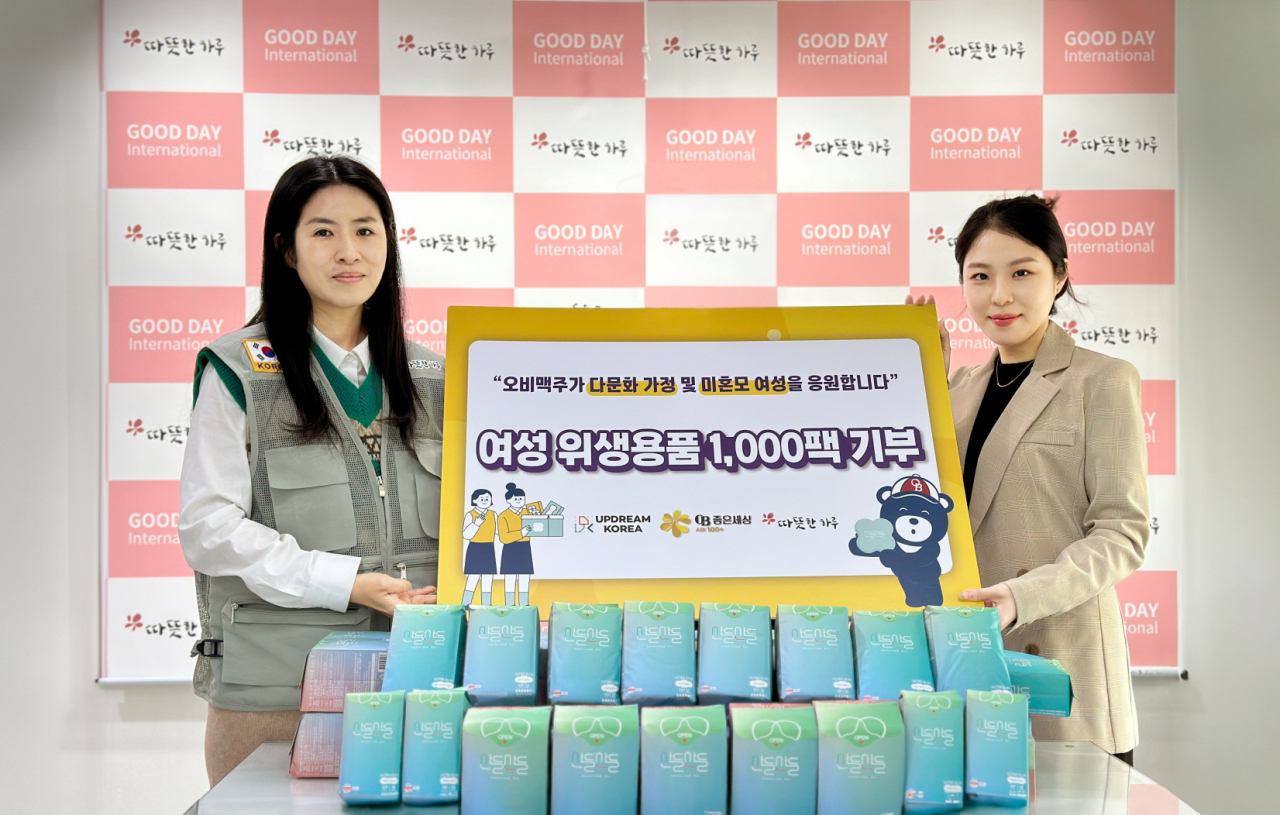 박윤미(왼쪽부터) 따뜻한 하루 기획홍보국 국장과 최하희 업드림코리아 매니저가 여성 위생용품 전달식 후 기념사진을 찍고 있다. [오비맥주 제공]