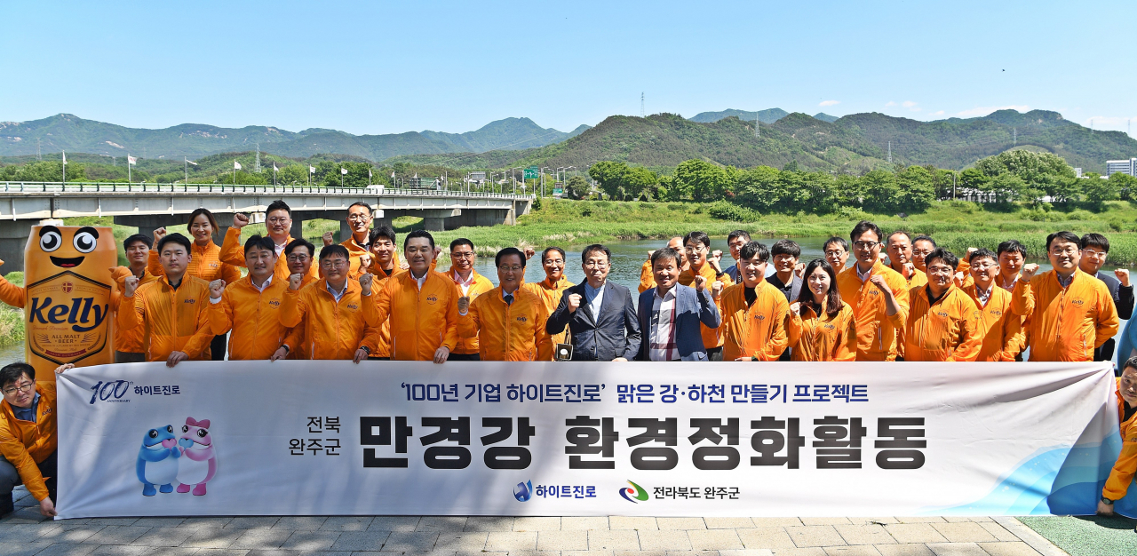 하이트진로가 지난 13일 전북 완주군 만경강에서 하이트진로 김인규 대표(앞줄 왼쪽 네번째), 완주군 유희태 군수(앞줄 왼쪽 다섯 번째) 등이 참석한 가운데 만경강 환경정화활동을 진행했다. [하이트진로 제공]