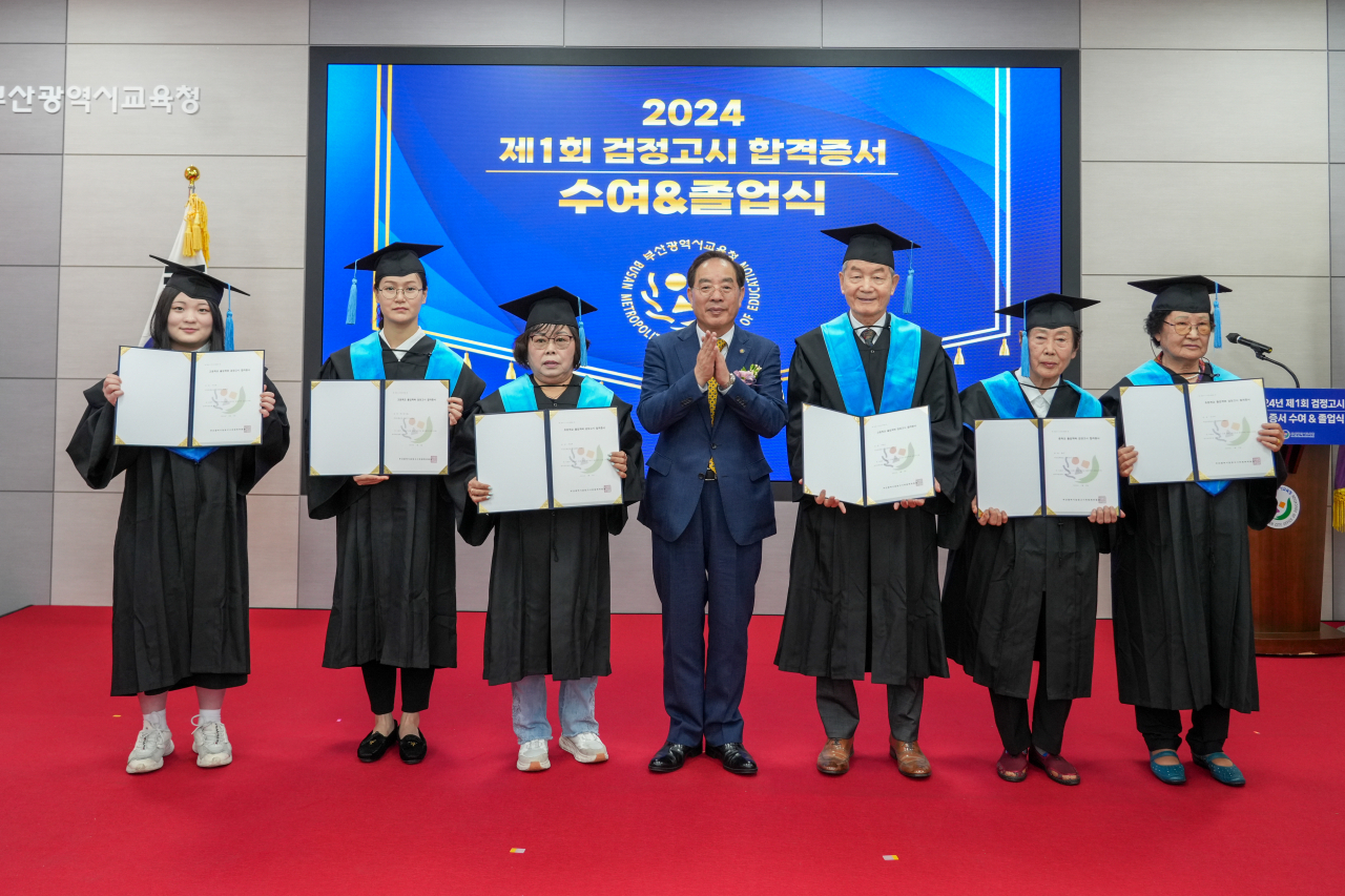 하윤수 부산시교육감(가운데)이 14일 오전 부산시교육청 별관 국제회의실에서 열린 ‘2024년 제1회 검정고시 합격증서 수여식’에 참석해 합격자들에게 합격증서를 수여한 뒤 기념촬영을 하고 있다. [사진=부산교육청]