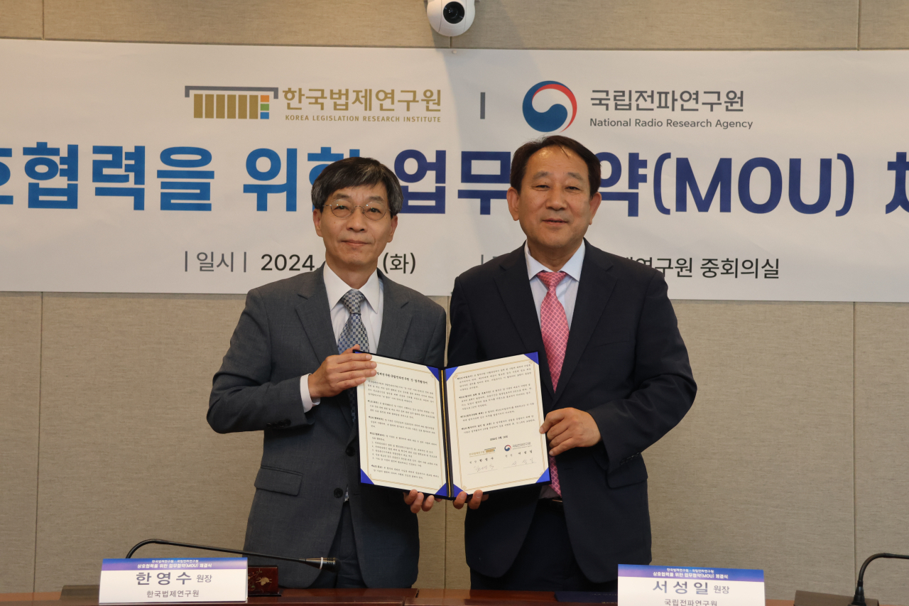 한영수(오른쪽) 한국법제연구원장과 서성일 국립전파연구원장이 협약서를 들어 보이고 있다.[한국법제연구원 제공]