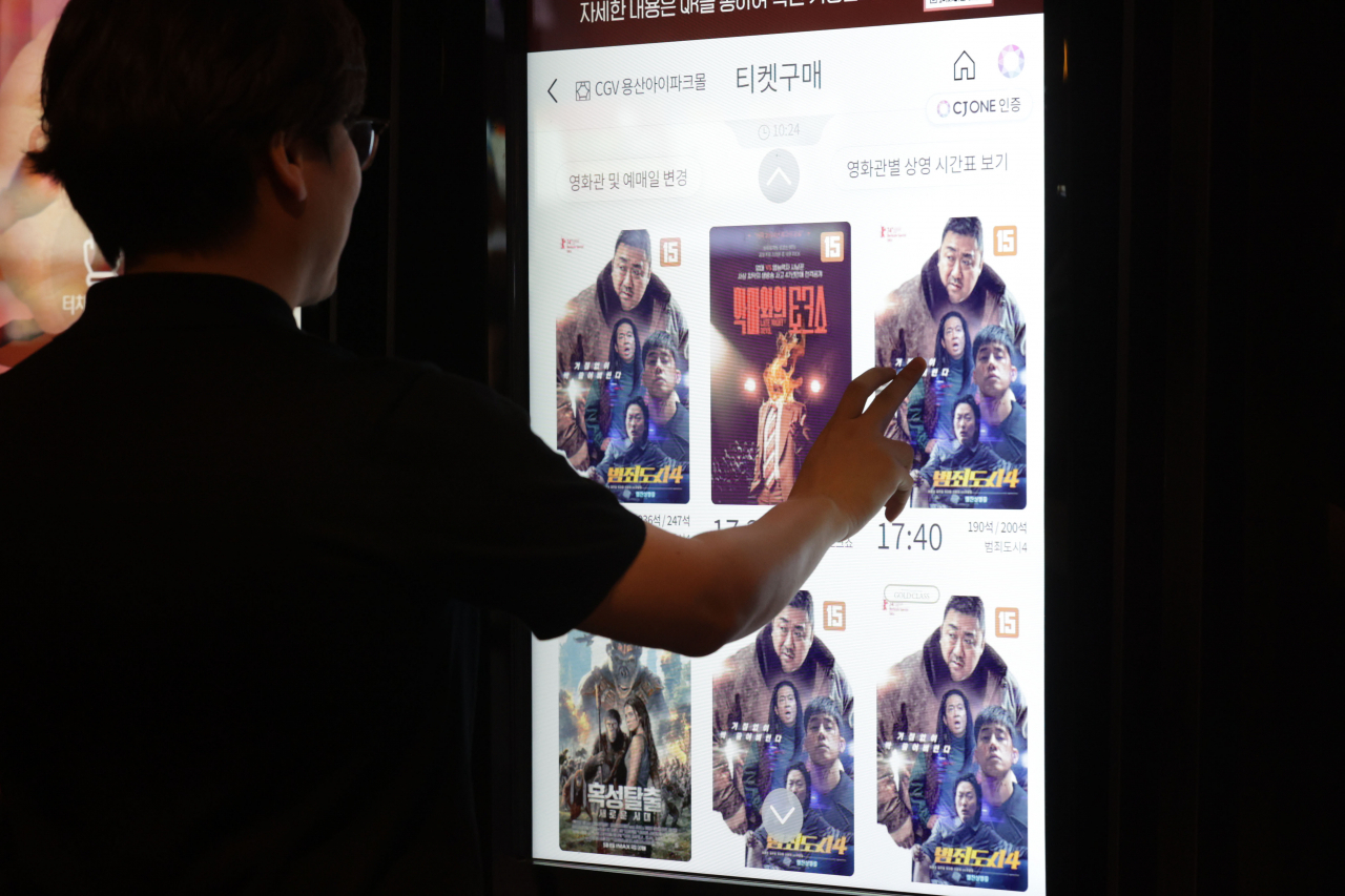 A man buys a ticket for "The Roundup: Punishment" at a movie theater in Seoul on Thursday. (Yonhap)