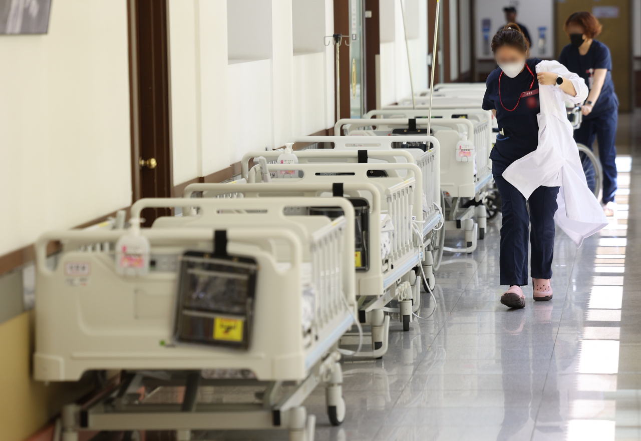 법원의 의대증원 효력 정지 여부 결정을 앞두고 의정갈등이 이어지고 있는 15일 대구 한 대학병원에서 의료관계자가 가운을 입으며 이동하고 있다. [연합}