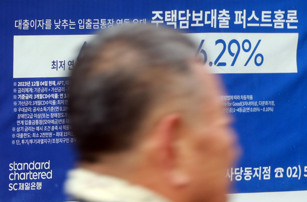 서울 한 시중은행 영업점의 대출 안내문 앞을 시민이 지나가고 있다.[연합]