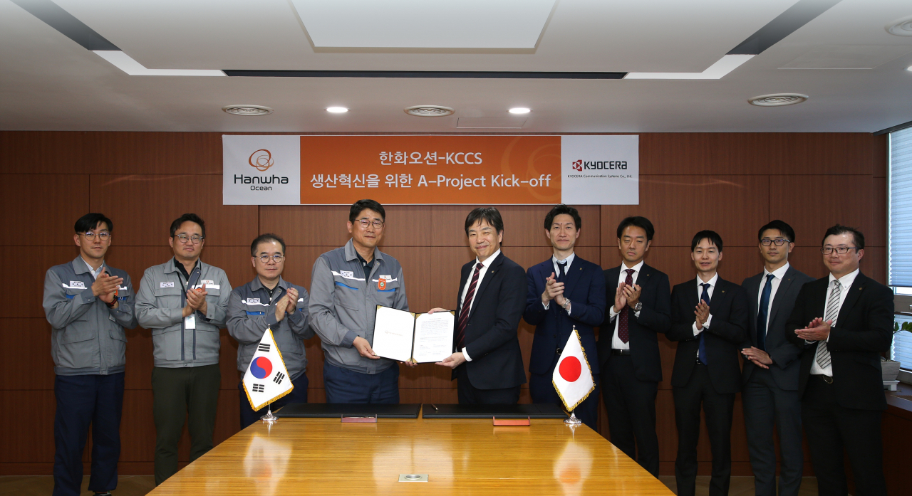 이길섭(왼쪽 네 번째부터) 한화오션 조선소장 부사장과 마츠나가 카즈히로 교세라 사업부장이 계약서에 서명한 뒤 기념촬영을 하고 있다. [한화오션 제공]