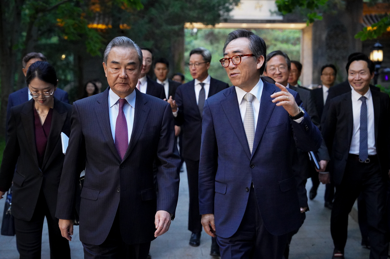조태열 외교 장관과 왕이 중국공산당 중앙외사판공실 주임(외교부장 겸임)이 한중 외교장관 회담이 열린 13일 중국 베이징 댜오위타이(釣魚臺) 국빈관에서 산책을 하며 대화를 나누고 있다. [연합]