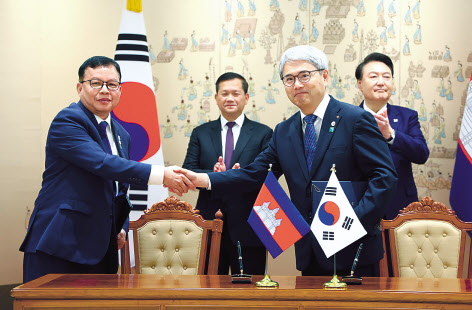 윤희성(앞줄 오른쪽) 한국수출입은행장과 루어 세일라와(앞줄 왼쪽) 캄보디아 경제재정부 차관이 16일 서울 용산 대통령실 청사에서 윤석열 대통령과 훈 마넷 캄보디아 총리가 배석한 가운데 열린 문서 서명식에서 ‘지방도로 개선사업 4차 대외경제협력기금 차관 계약’에 서명한 뒤 악수를 하고 있다. [연합]