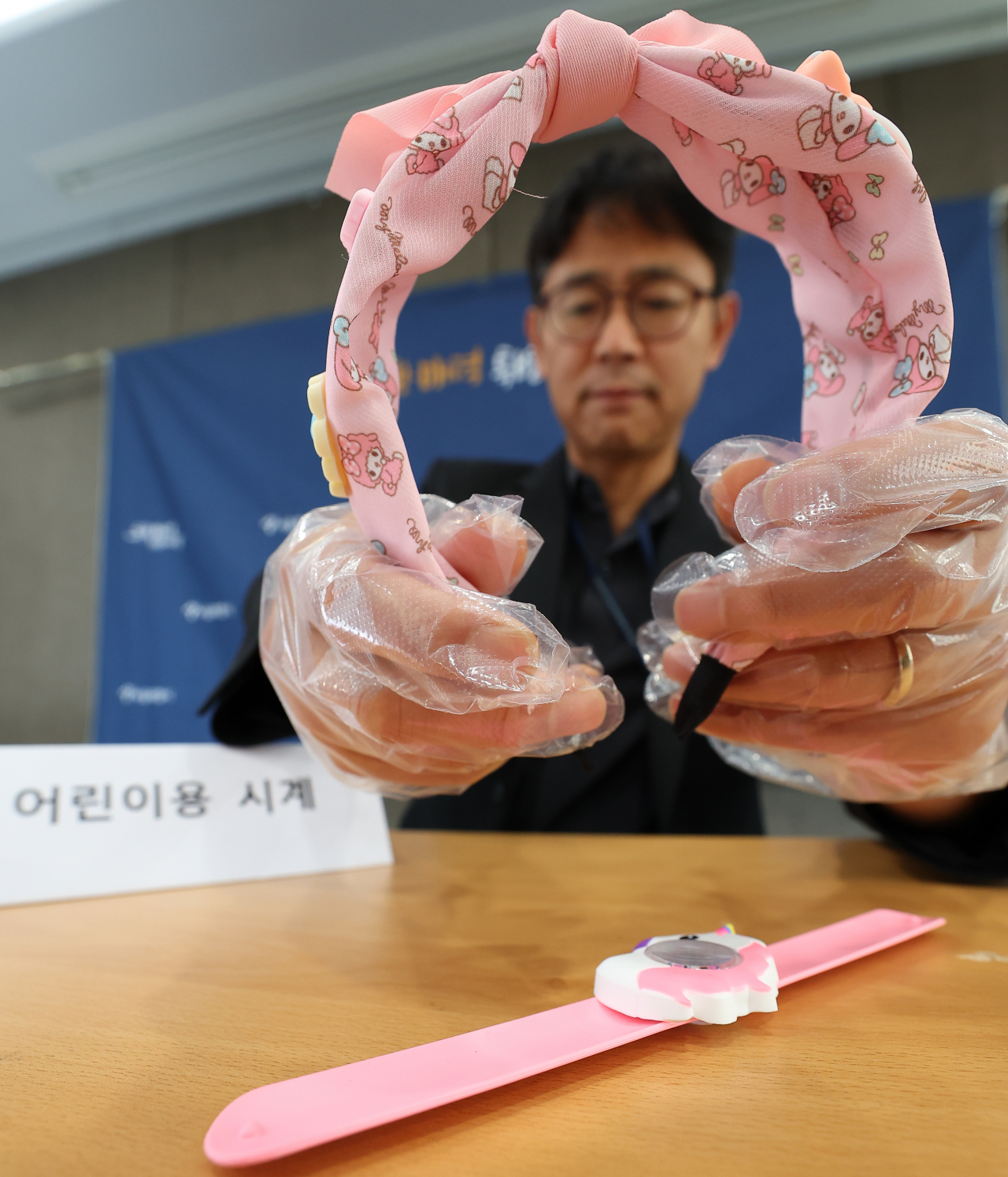 16일 오전 서울시청에서 박상진 소비자보호팀장이 인체발암 가능 물질이 검출된 해외직구 어린이용 머리띠와 시계를 들어 보이고 있다. [연합]