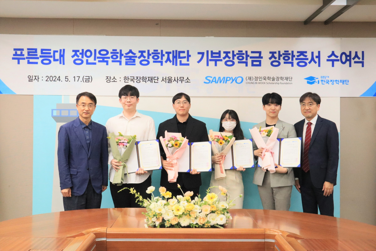 배성근(사진 왼쪽) 한국장학재단 장학이사와 유용재 정인욱학술장학재단 사무국장(사진 오른쪽)이 지난 17일 한국장학재단 서울사무소 대회의실에서 학생들과 기념 촬영을 하고 있다. [삼표 제공]