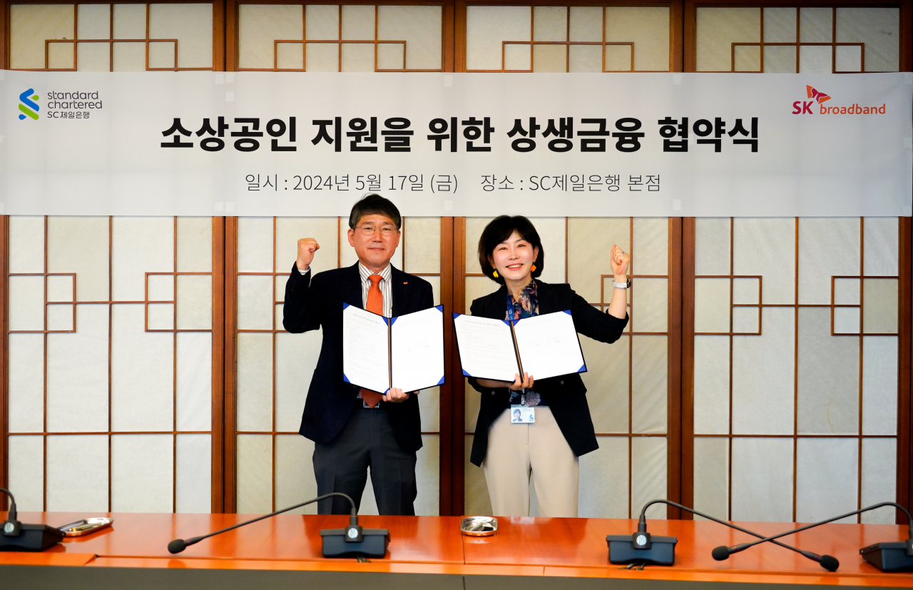 최정호(왼쪽) SK브로드밴드 수도권 CP장과 김단주 SC제일은행 비즈니스뱅킹부문장이 지난 17일 서울 종로구 SC제일은행 본사에서 가진 ‘소상공인 지원을 위한 상생금융 협약식’에서 기념사진을 찍고 있다. [SK브로드밴드 제공]