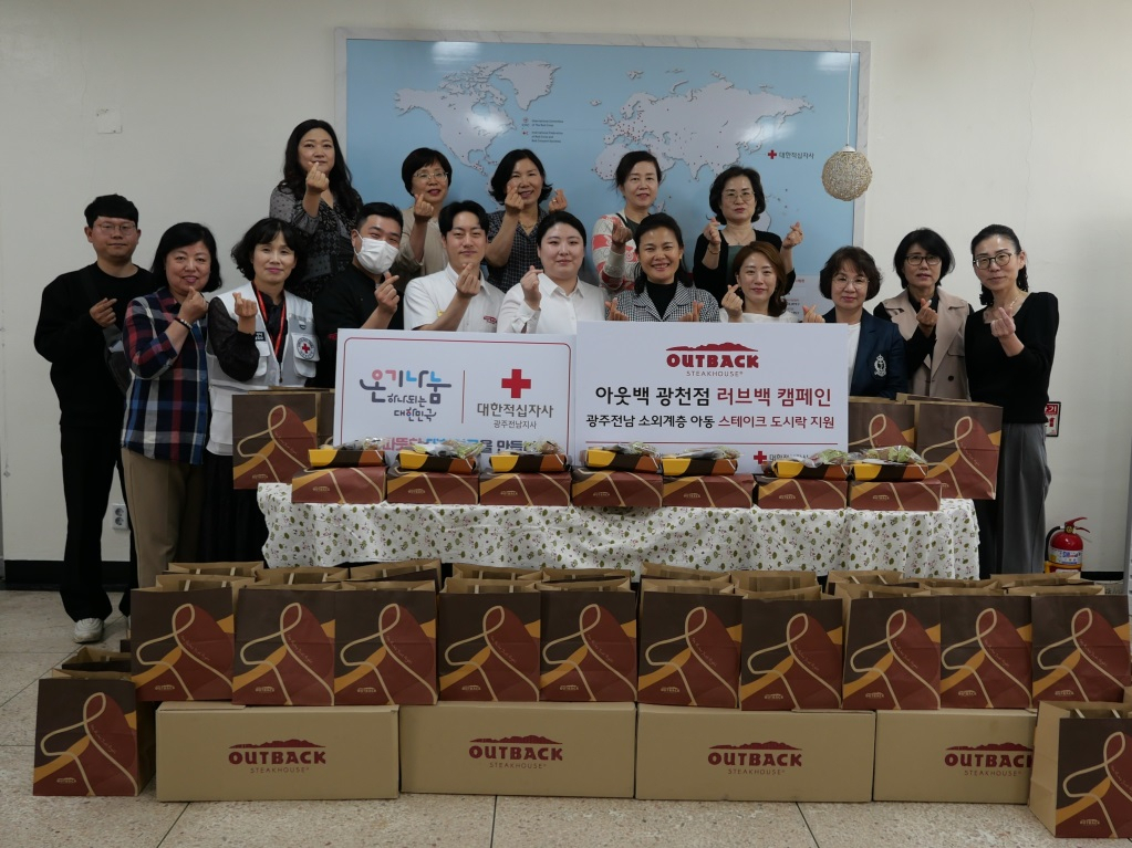 아웃백 광주광천점 이나은 점주(첫번째 줄 왼쪽에서 여섯번째)와 임직원이 대한적십자사 광주전남지사 및 지역아동센터 관계자들과 스테이크세트 나눔 행사 뒤 기념사진을 촬영하고 있다. [아웃백 제공]