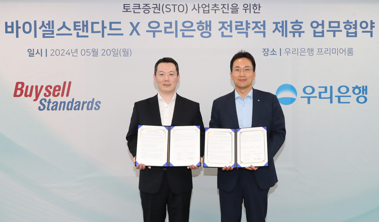 우리은행(은행장 조병규)이 20일 서울 중구 우리은행 본점에서 진행한 바이셀스탠다드와의 토큰증권 활성화 업무협약식에서 옥일진(오른쪽) 우리은행 디지털전략그룹장과 신범준 바이셀스탠다드 대표이사가 기념촬영을 하고 있다. [우리은행 제공]