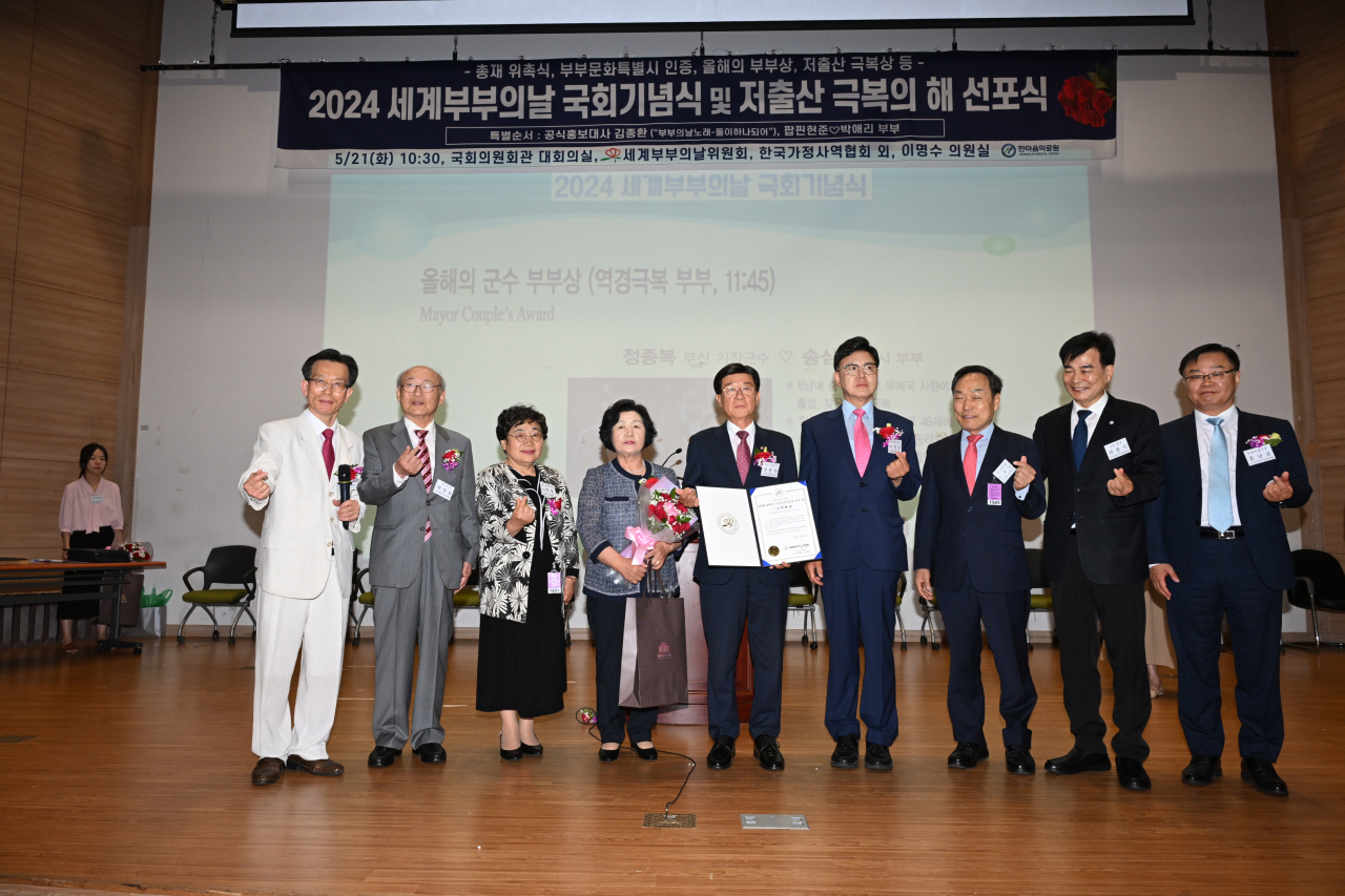 정종복 기장군수(가운데)와 부인 송삼선 여사(왼쪽 네 번째)가 21일 국회의원회관에서 열린 ‘2024 세계 부부의 날 국회기념식’에서 전국 시장 군수 구청장 부문 ‘올해의 군수 부부상’을 수상하고 있다. [사진=기장군]