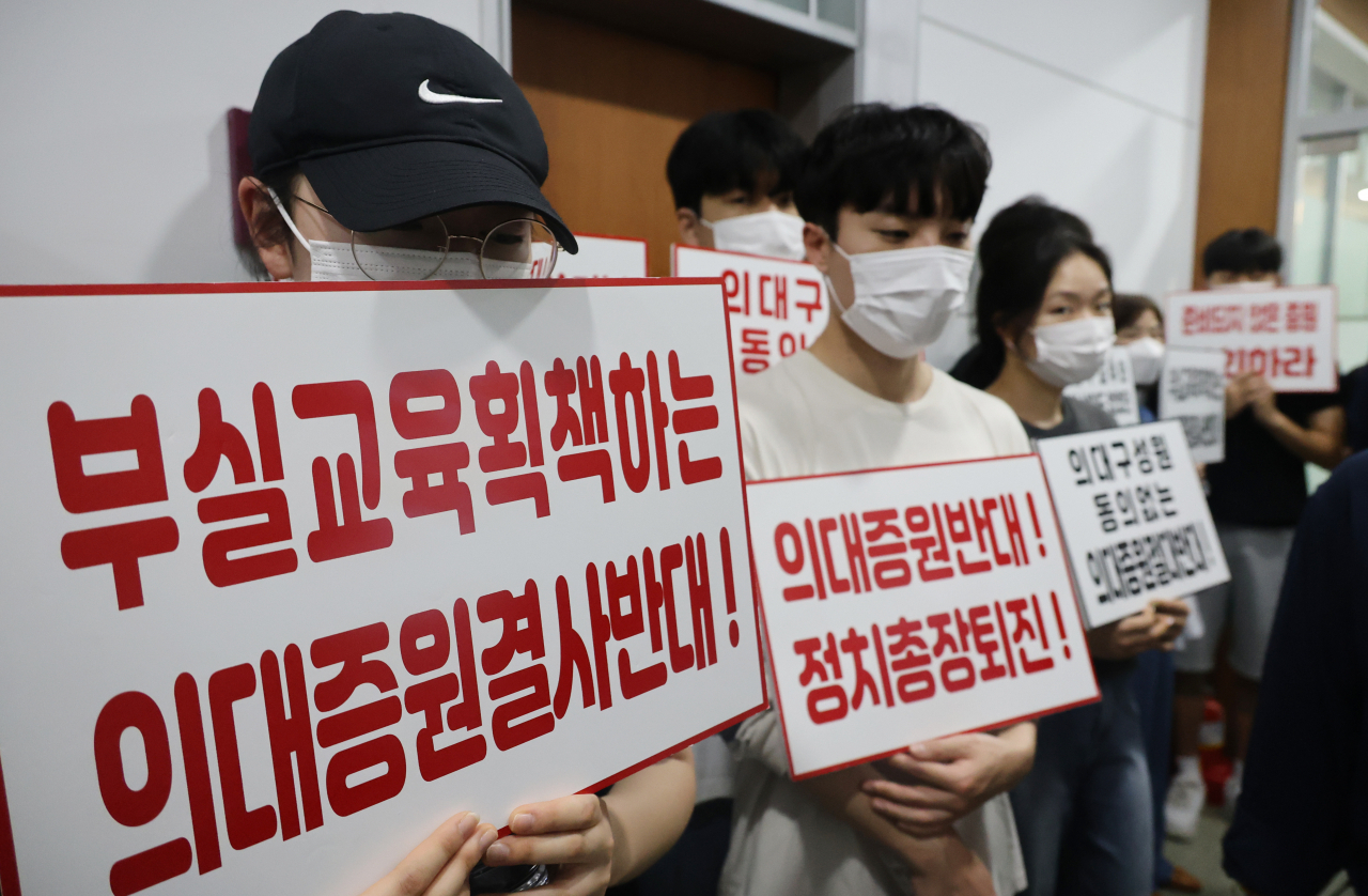 충북대 의대 교수·학생 등 50여명이 21일 오후 학칙개정안을 심의하는 교무회의가 열리는 충북대학교 대학본부 5층 대회의실 앞 복도에서 증원 반대 시위를 하고 있다. [연합]
