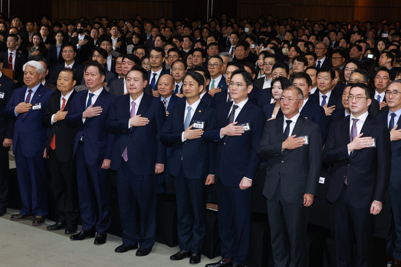 지난 3월 서울 영등포구 63컨벤션센터에서 열린 제51회 상공의 날 기념식에서 윤석열(오른쪽 다섯번째) 대통령이 기업인과 함께 국기에 경례하고 있다. 구광모(오른쪽부터) LG그룹 회장, 정의선 현대차 회장, 이재용 삼성전자 회장, 안덕근 산업통상자원부 장관, 윤 대통령, 최태원 대한상공회의소 회장 [연합]