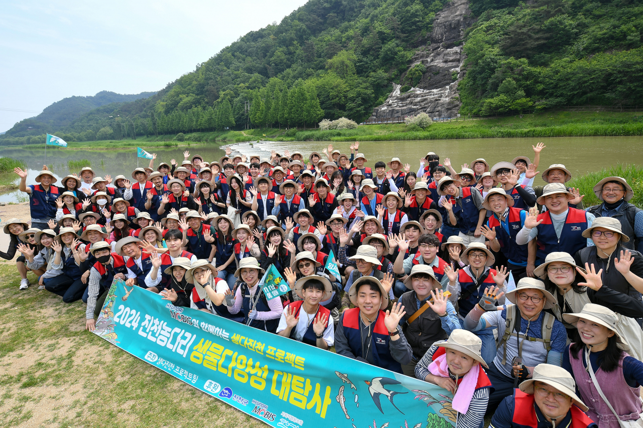충북 진천군 미호강 일대에서 열린 ‘2024년 생물대탐사’에 참여한 현대모비스 임직원들이 기념 촬영을 하고 있다. [현대모비스 제공]