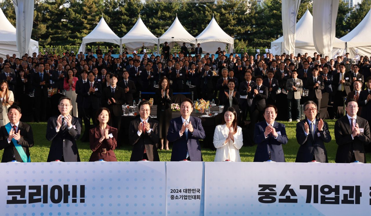 윤석열 대통령이 23일 서울 용산 대통령실 잔디마당에서 열린 '2024 대한민국 중소기업인대회'에서 참석자들과 '글로벌 원팀(One Team)호 출항식' 퍼포먼스에 참여하고 있다. 김정희(왼쪽부터) 에이치엔에스하이텍대표, 이재용 삼성전자 회장, 오영주 중소벤처기업부 장관, 박진수 콜로세움 코퍼레이션 대표, 윤 대통령, 이하나 멜릭서 대표, 김기문 중소기업중앙회장, 조태열 외교부 장관, 구광모 LG 회장. [연합]