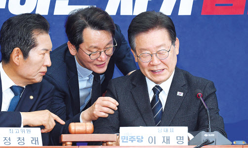 추이재명 더불어민주당 대표가 같은 날 국회에서 열린 최고위원회의에서 한 당직자가 전달한 메모를 정청래 최고위원과 살펴보고 있다. 이상섭 기자