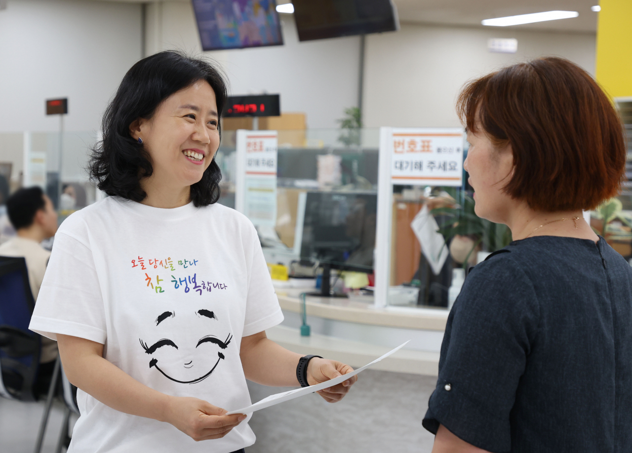 서울 강남구는 민원 담당 공무원들이 27일부터 특별 제작한 ‘시(詩)셔츠’를 입고 근무한다고 밝혔다. 시셔츠를 입은 강남구 민원 담당 공무원이 민원인을 응대하고 있다.[강남구 제공]