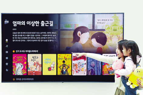 LG유플러스 직원이 어린이와 스마트TV를 통해 ‘아이들나라’ 콘텐츠를 시청하고 있다.